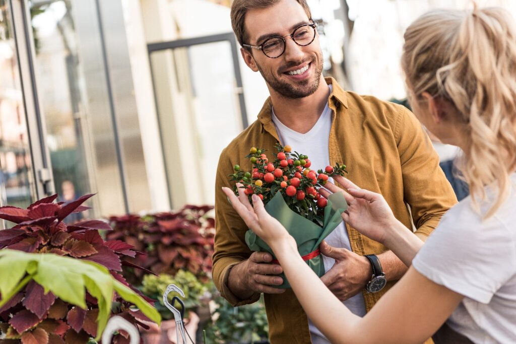 Man gifting a bouquet of flowers to a woman outdoors